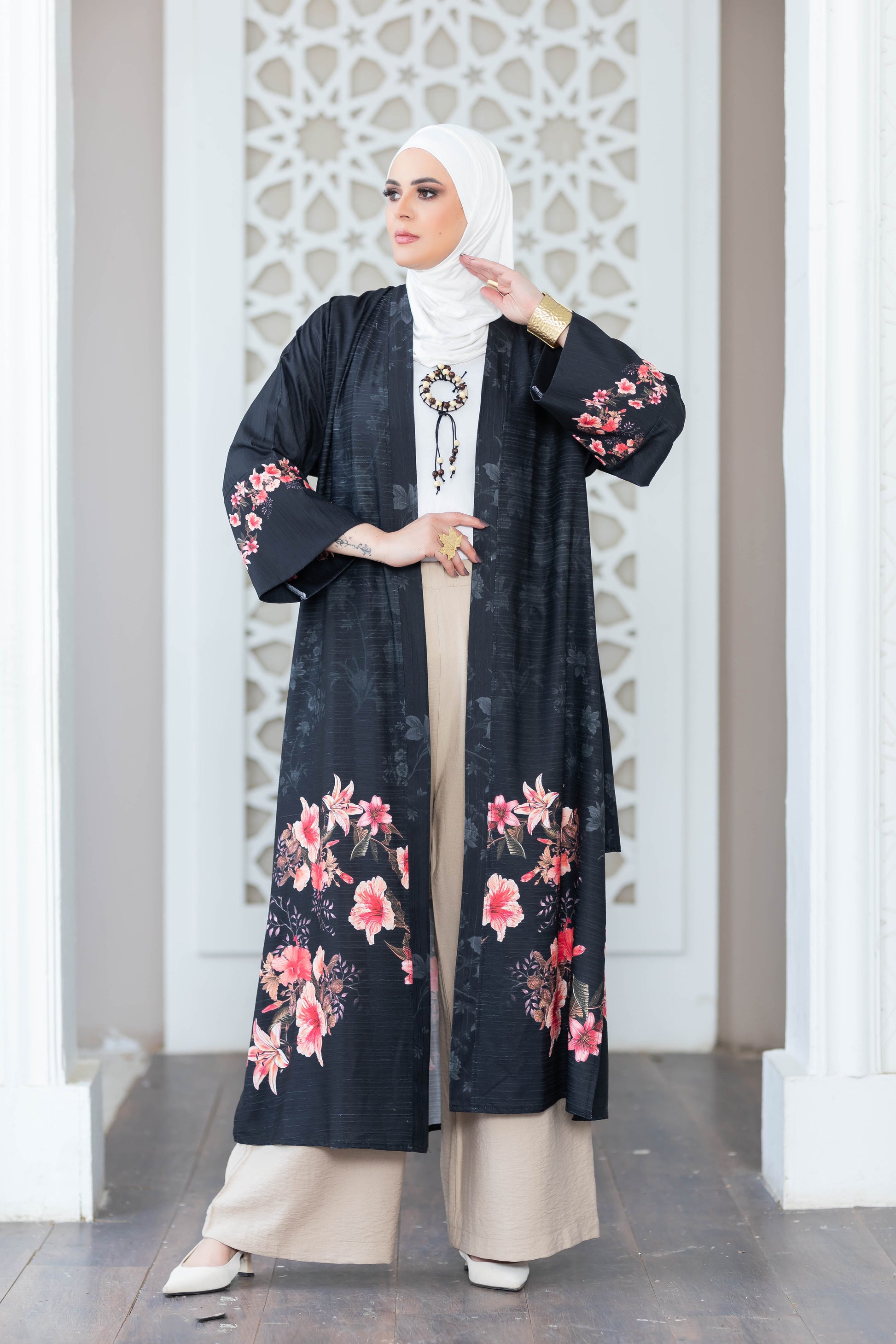 Elegant floral kimono with intricate embroidery design, worn by a woman in a modern Islamic fashion style.