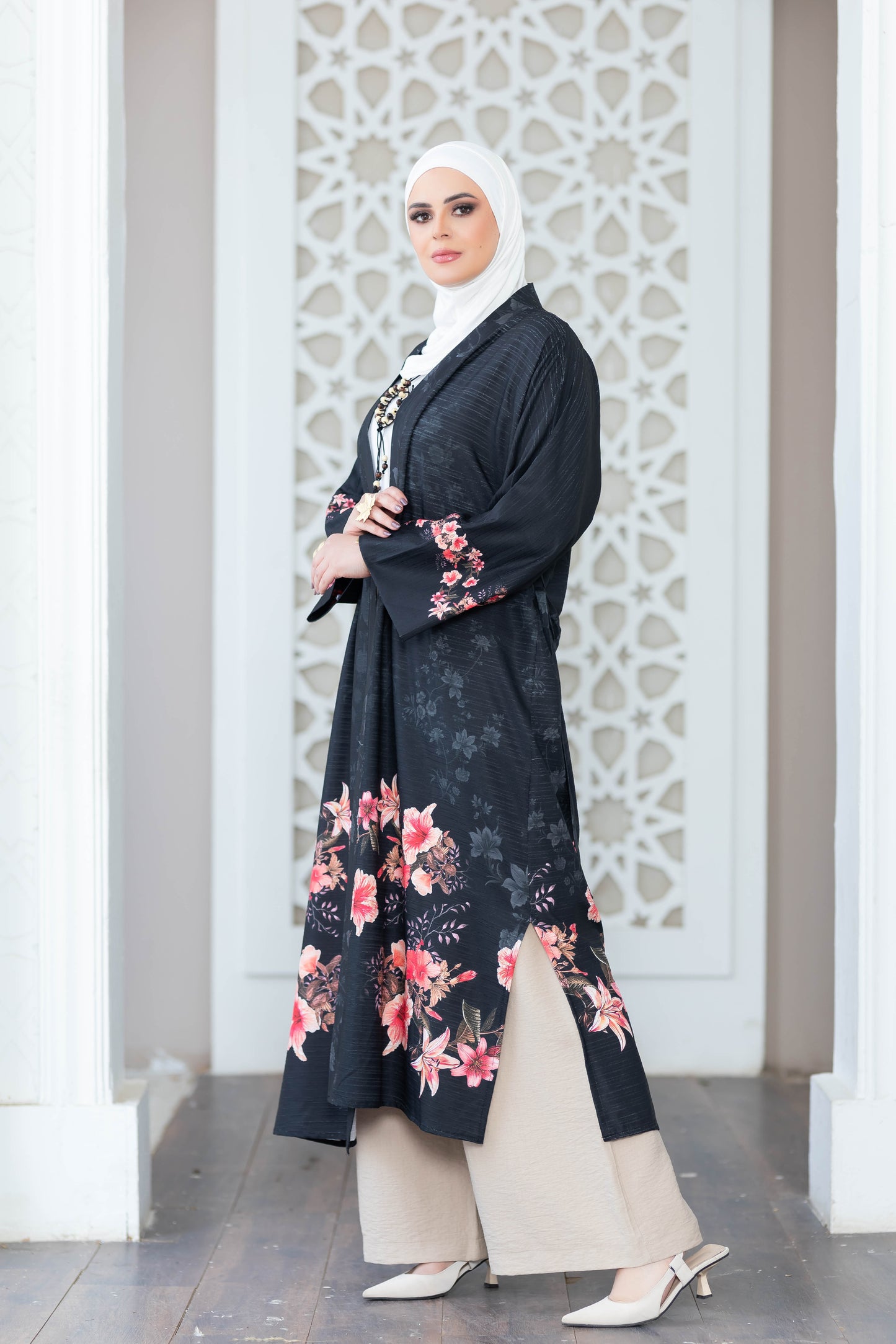 Elegant floral-printed kimono on display, featuring a black background with pink and white flowers for a stylish and modest look.