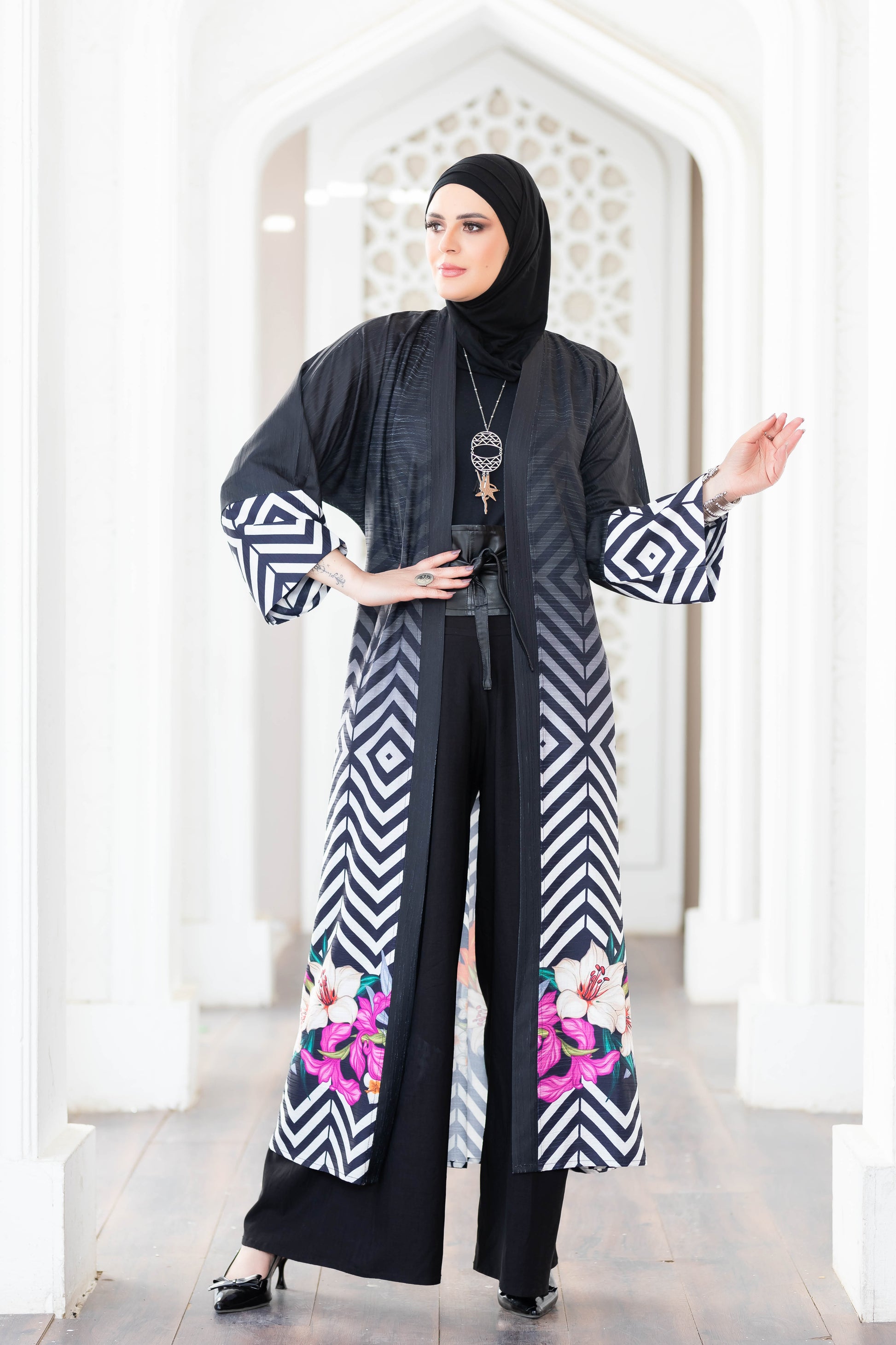 Stylish black and white digital print kimono with floral accents, worn by a woman in a traditional setting.