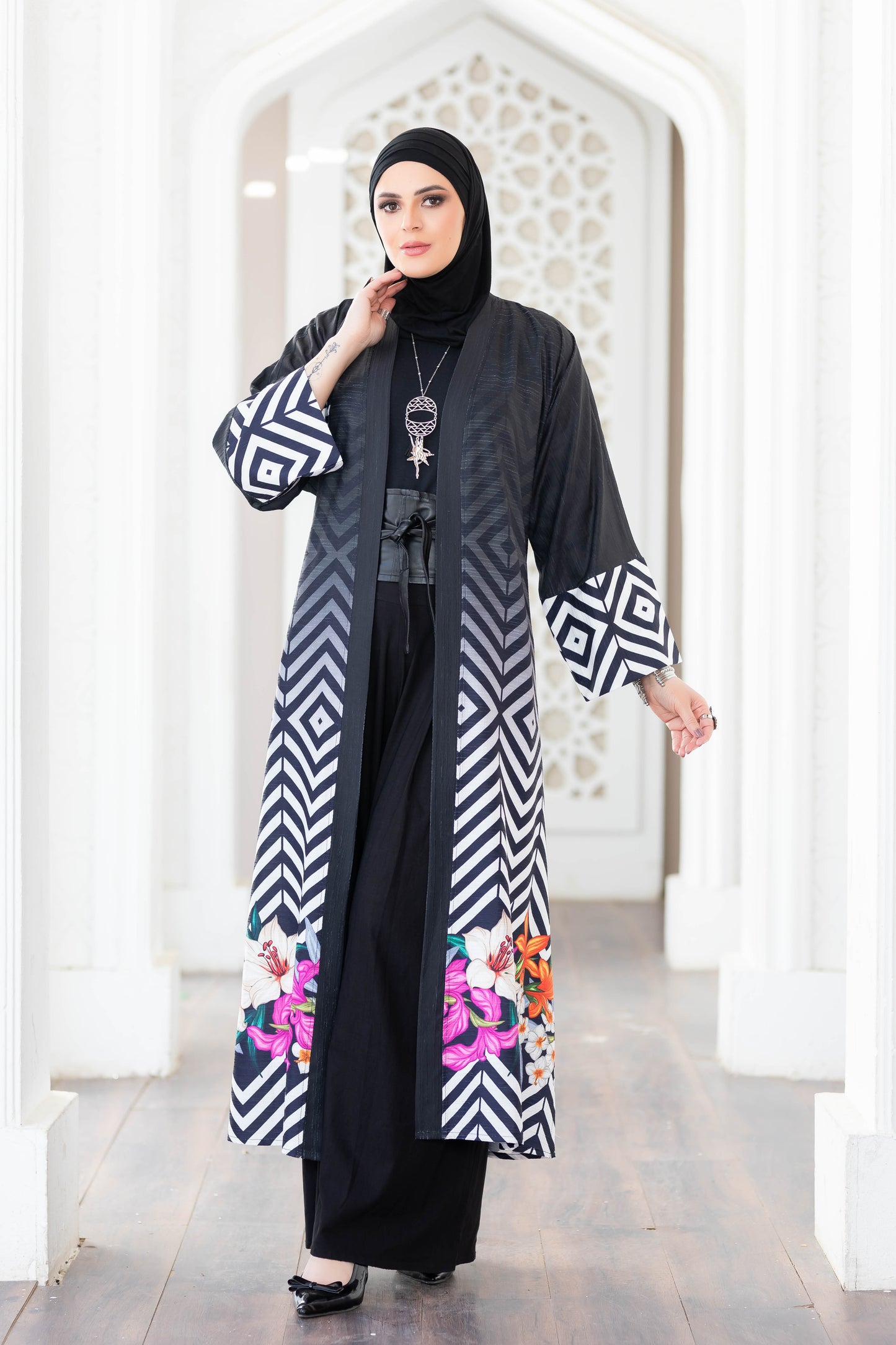 Elegant geometric-patterned digital print kimono with long sleeves and a flowing silhouette displayed against an architectural backdrop.