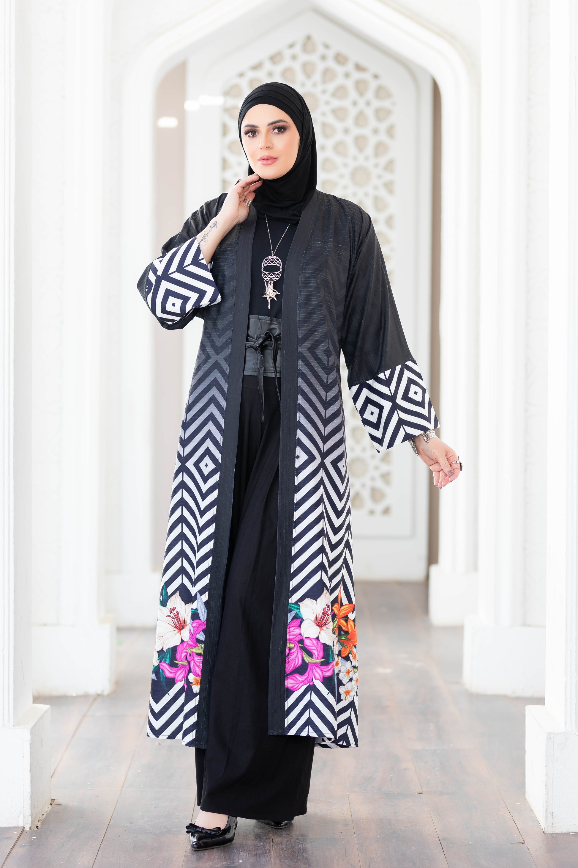 Elegant geometric-patterned digital print kimono with long sleeves and a flowing silhouette displayed against an architectural backdrop.