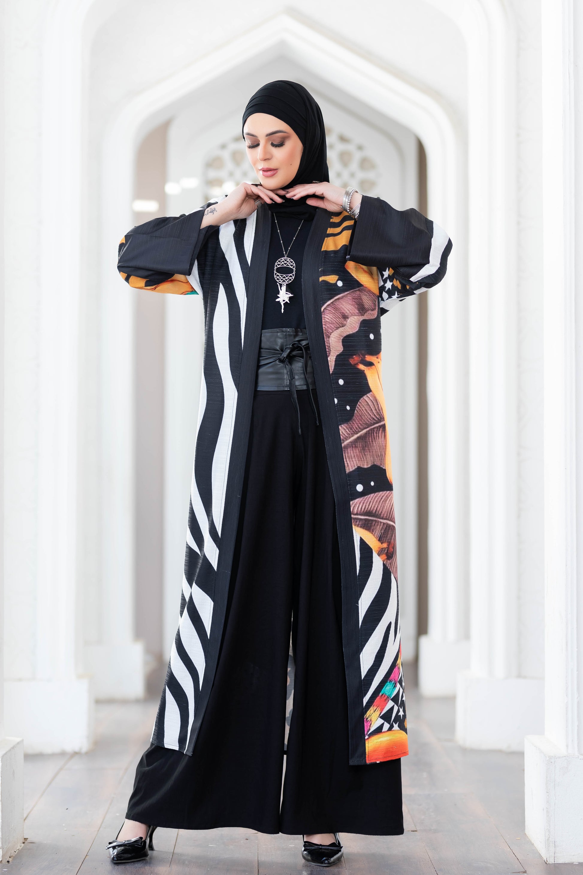 Stylish digital print kimono with bold patterns and colors, worn by a woman in a modern, artistic setting.