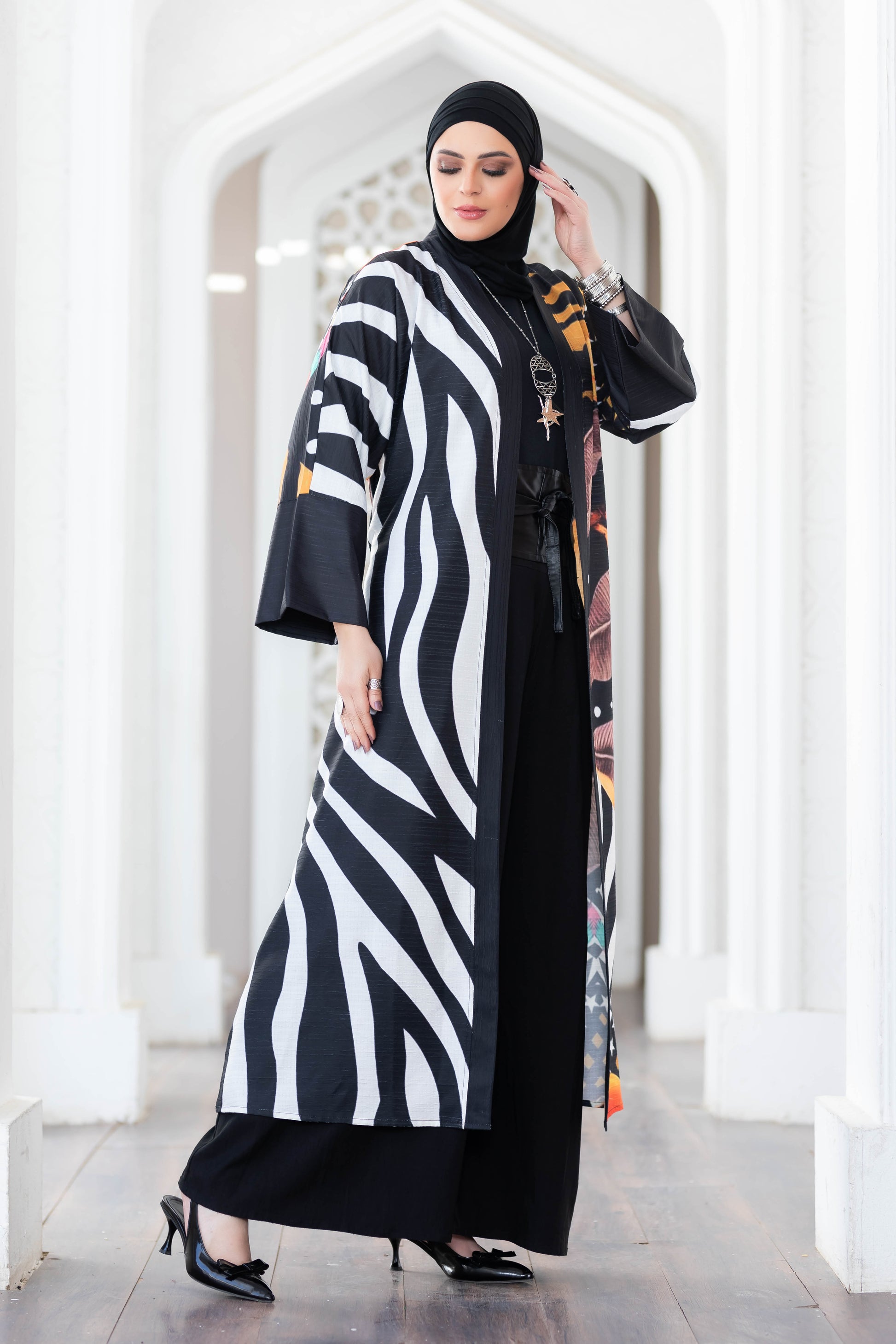 Stylish zebra-print kimono with elegant floral details, worn by a woman in traditional Islamic attire, showcasing a modern and fashionable design.