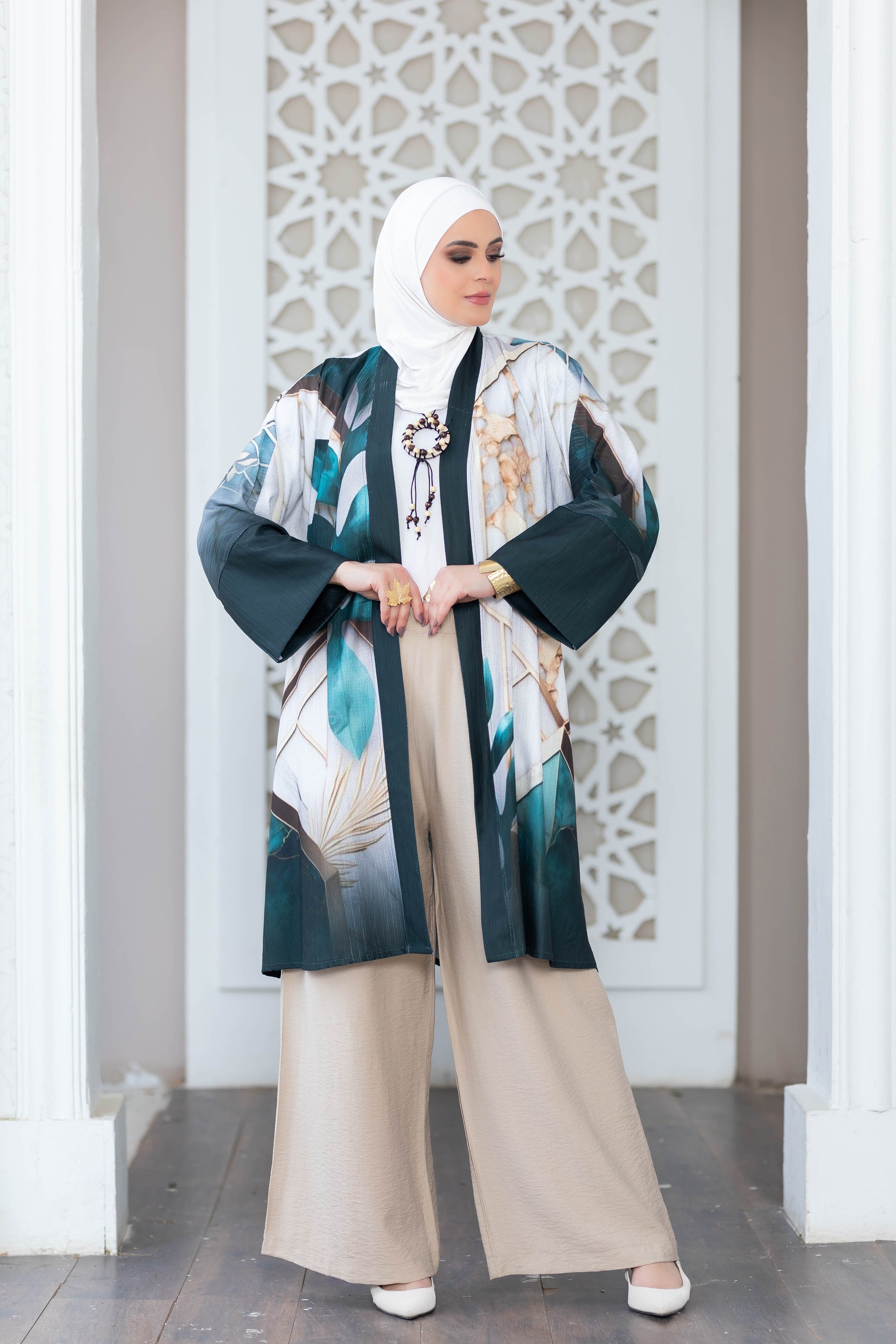 Vibrant printed kimono-style jacket with flowing sleeves, worn over neutral-toned pants, an elegant and stylish outfit.