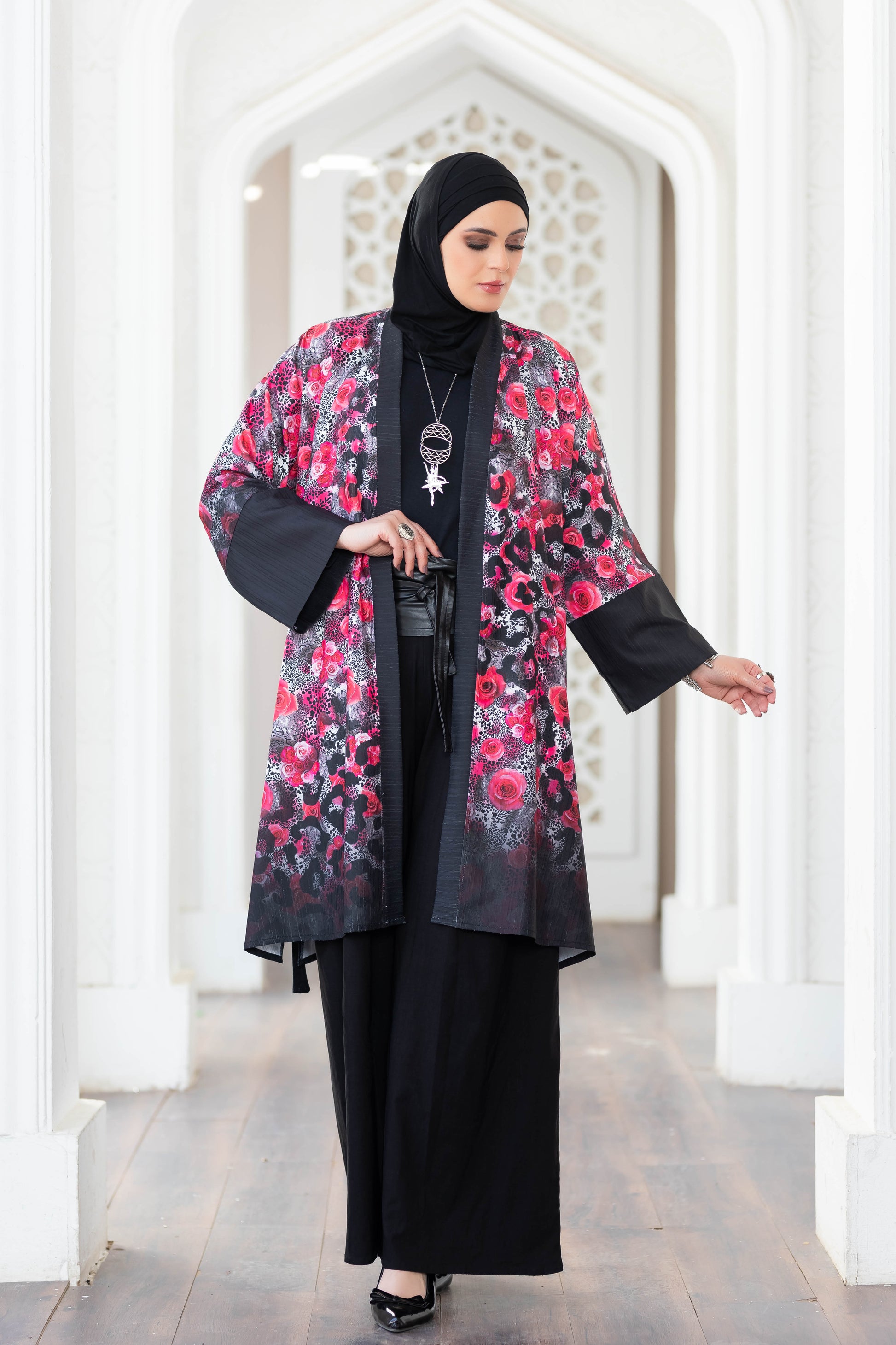 Colorful printed short kimono by satr, featuring floral design in pink and black tones, worn by a woman in traditional Islamic attire.