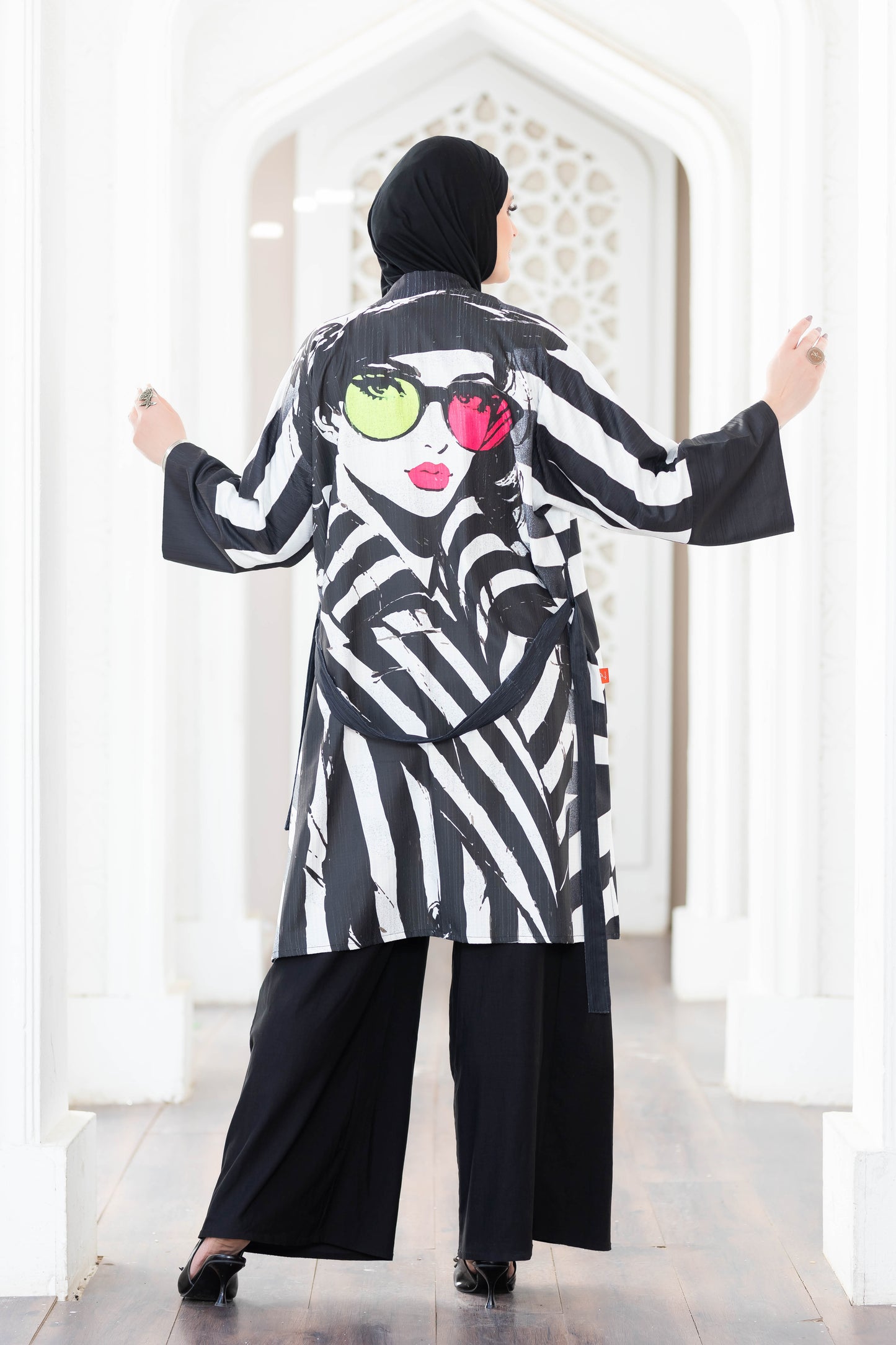 Stylish black and white striped kimono with vibrant pattern, worn by a female model in a modern setting.