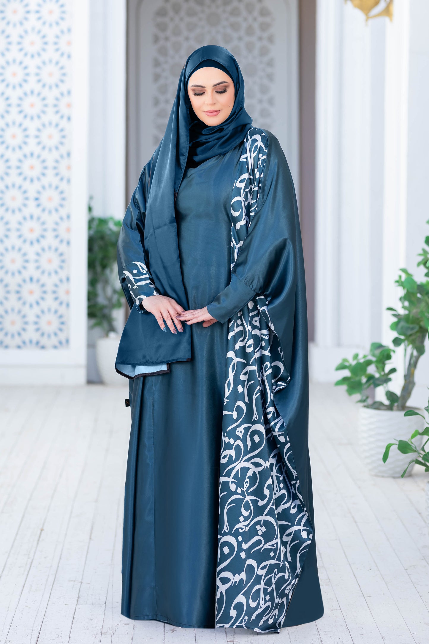 Modest satin dress with intricate embroidered patterns, worn by a woman in traditional Islamic attire.