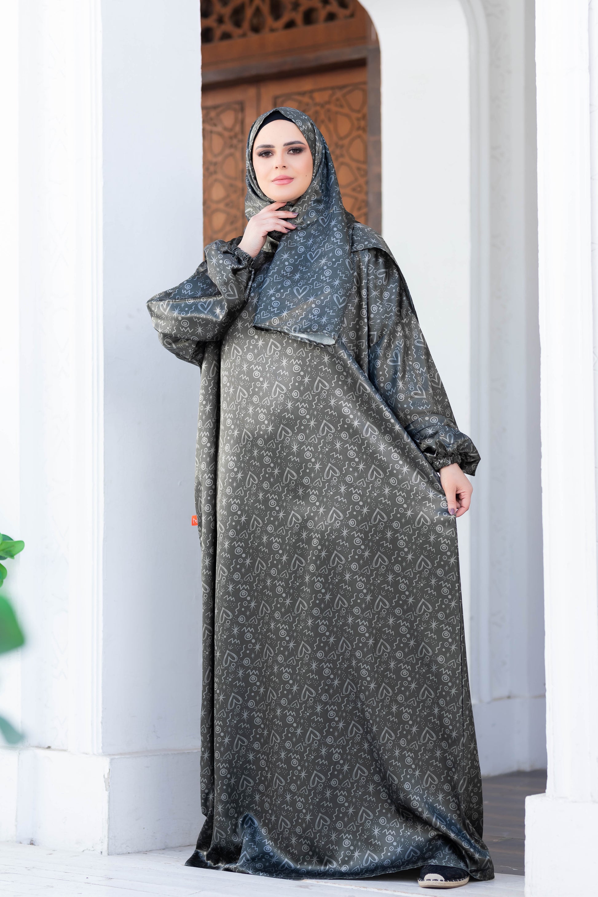 Modest grey marbled print clothing with hooded cape, worn by a woman indoors against a patterned archway.