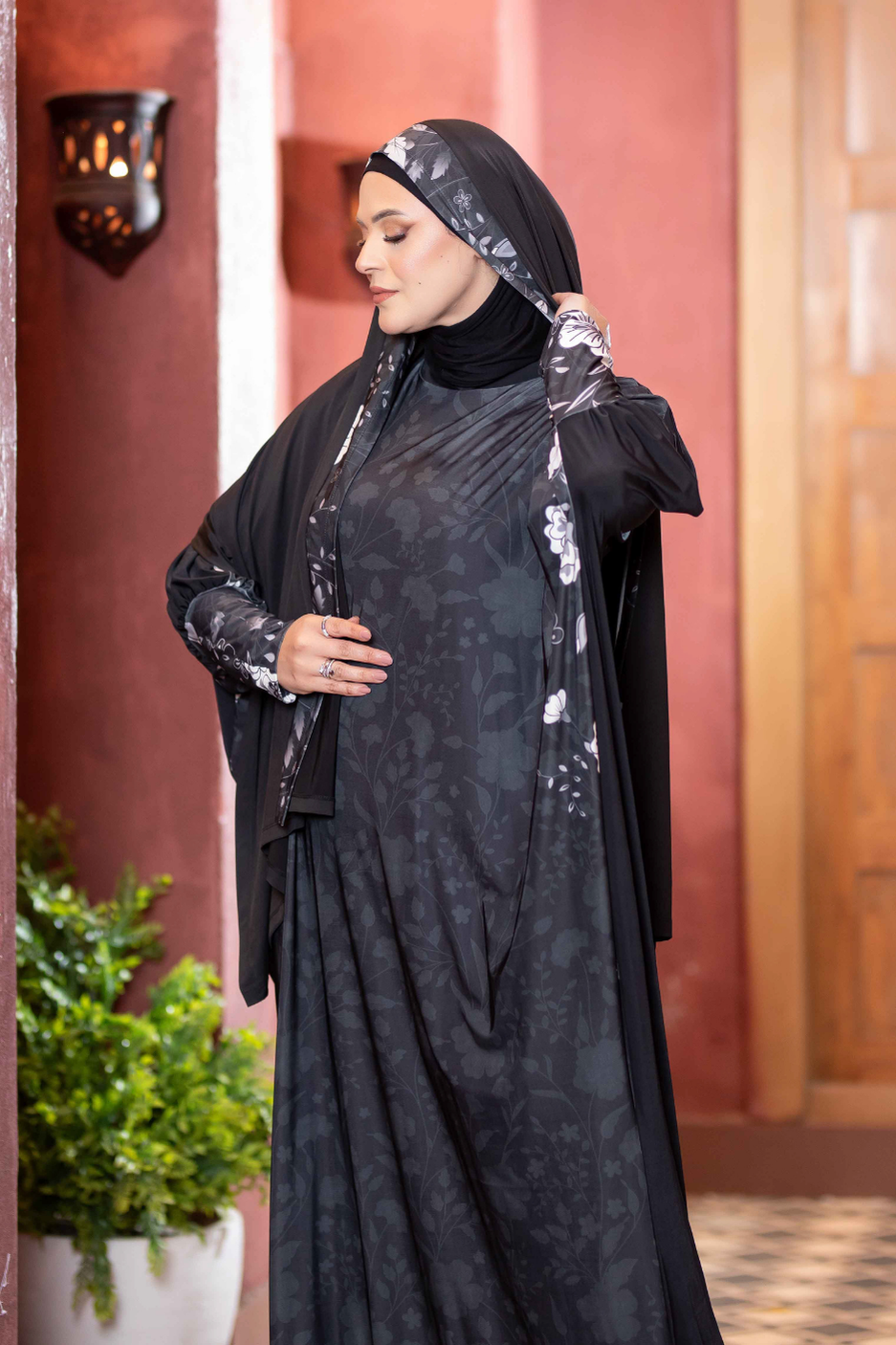 Elegant black hijab with floral pattern, long sleeve abaya, moderate yet captivating modest Islamic fashion for women.