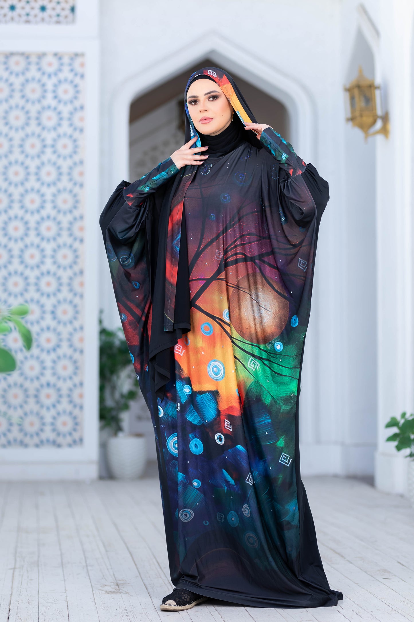 Modest Isdal 77713 ESDAL dress with vibrant, colorful floral pattern and loose, flowing silhouette displayed against a decorative architectural backdrop.