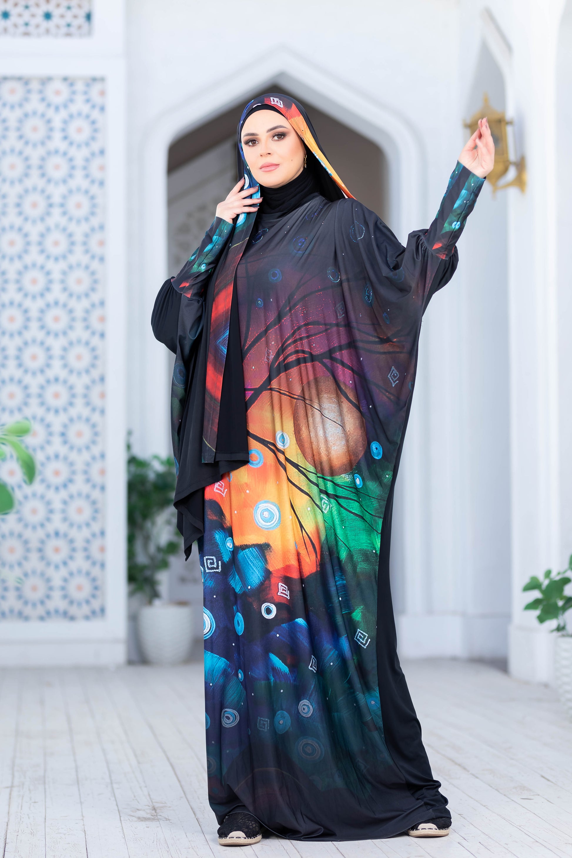 Vibrant Islamic modest dress with colorful abstract patterns, featuring long sleeves and billowing silhouette.