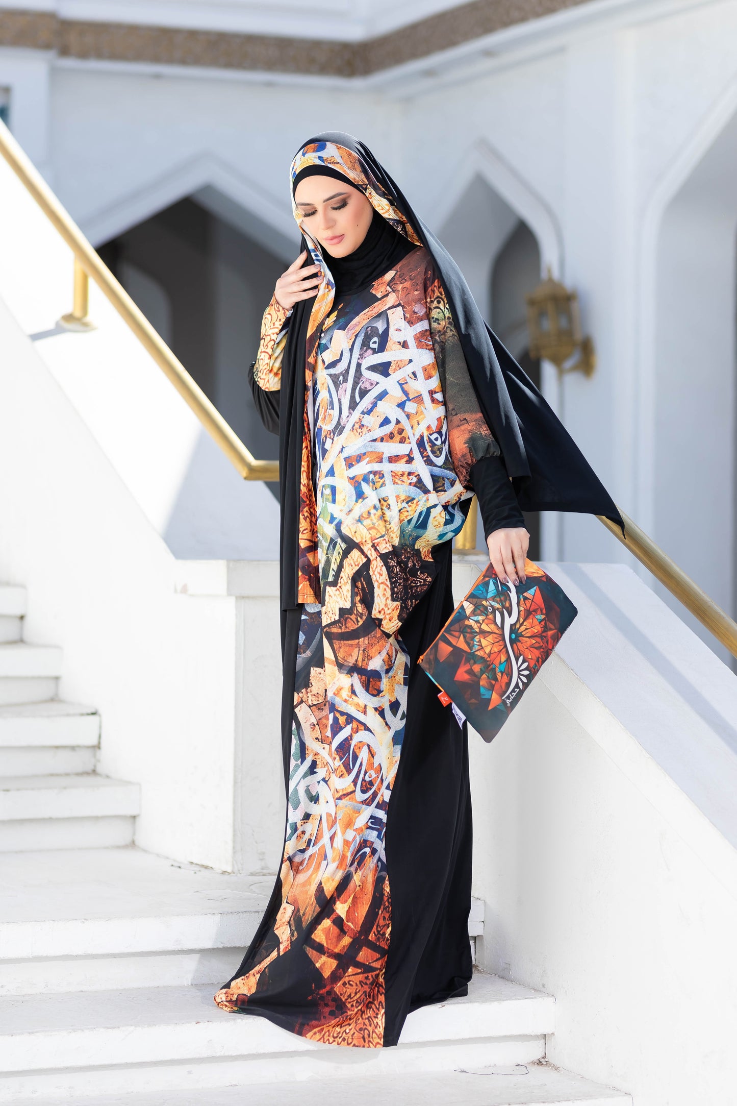 Modest Isdal 777141 - Vibrant patterned Islamic dress with hijab, styled with grace on ornate staircase