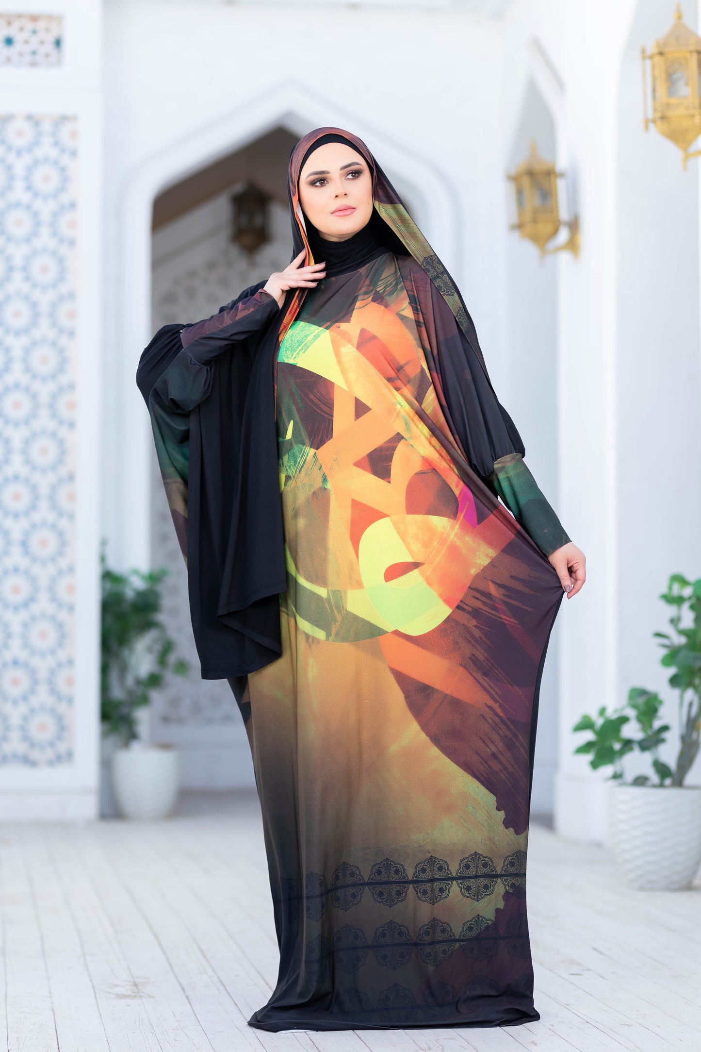 Modest Isdal 77717 - Abstract floral pattern abaya with black accents, worn by a woman in an ornate archway setting