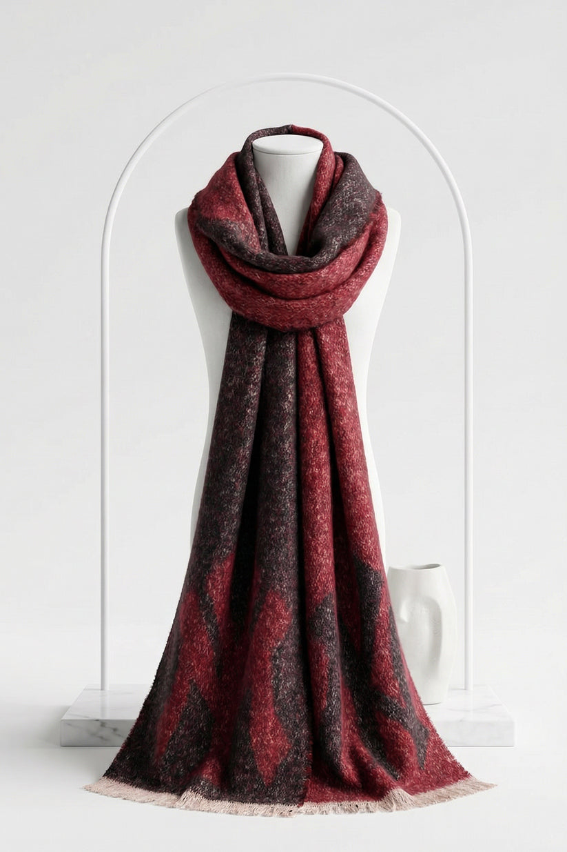 Red and brown patterned scarf on a mannequin against a white background