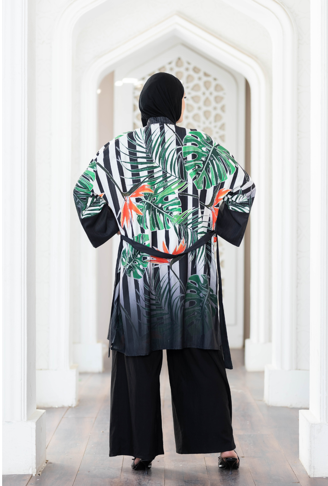 Tropical printed short kimono with black and white striped pattern displayed in a white architectural setting.