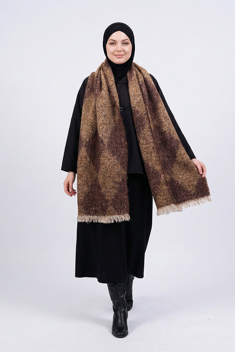 Woman wearing a black hijab, black coat, and brown patterned scarf on a white background