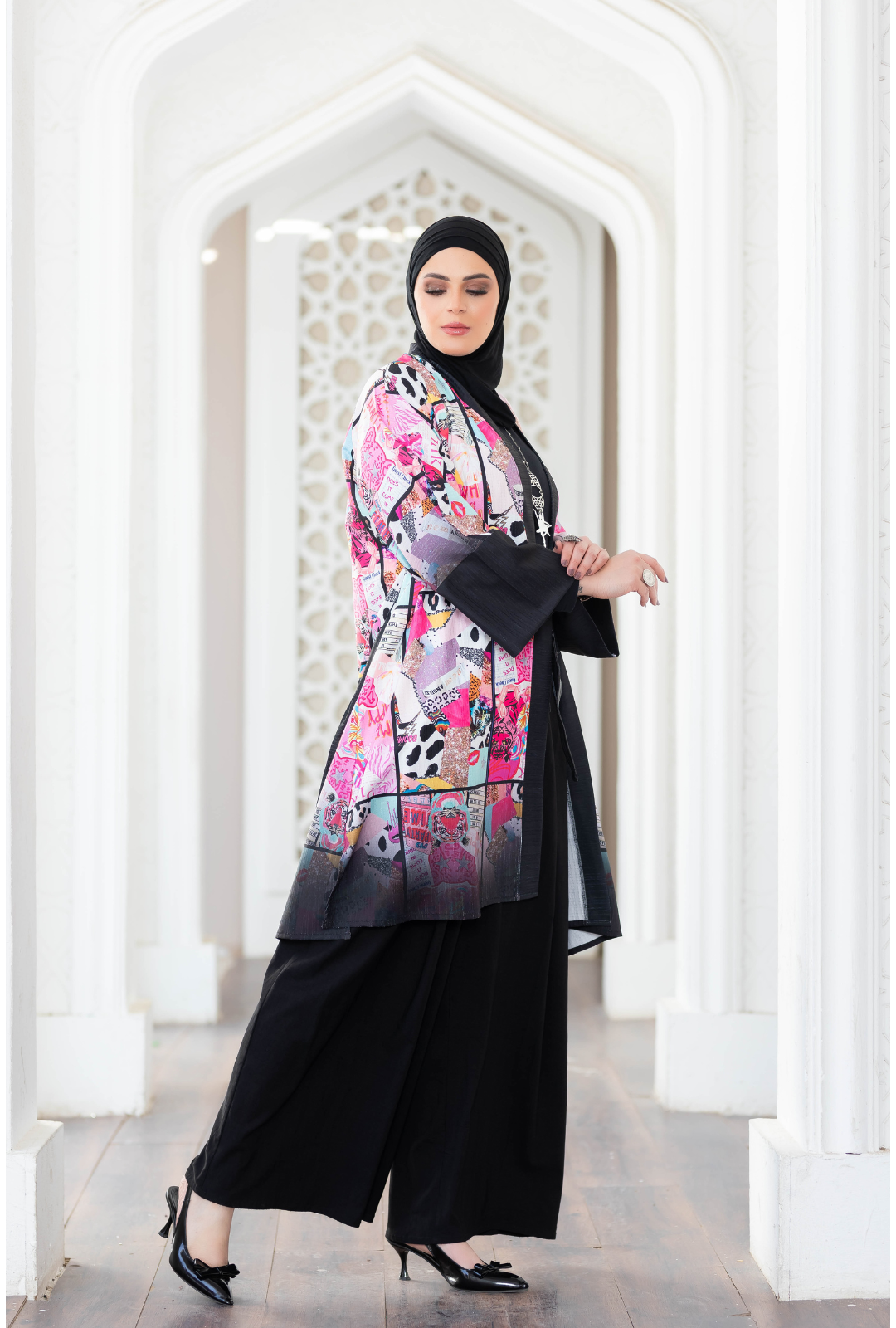 Colorful digital print kimono with intricate floral pattern, worn over black abaya by fashionable female model in traditional Islamic attire.