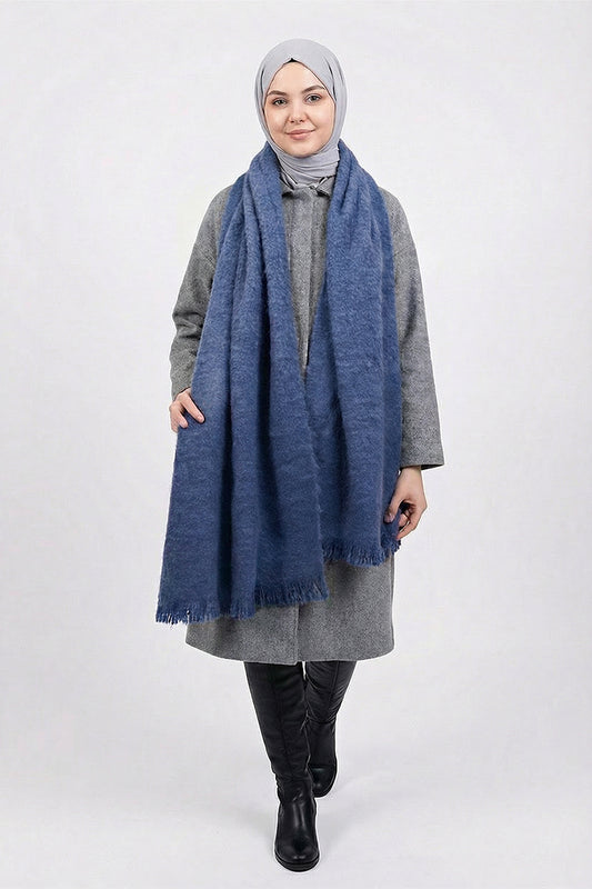 Woman wearing a blue scarf and gray outfit on a white background