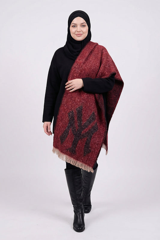 Woman wearing a red patterned scarf with a logo, black hijab, black top, and black boots on a white background