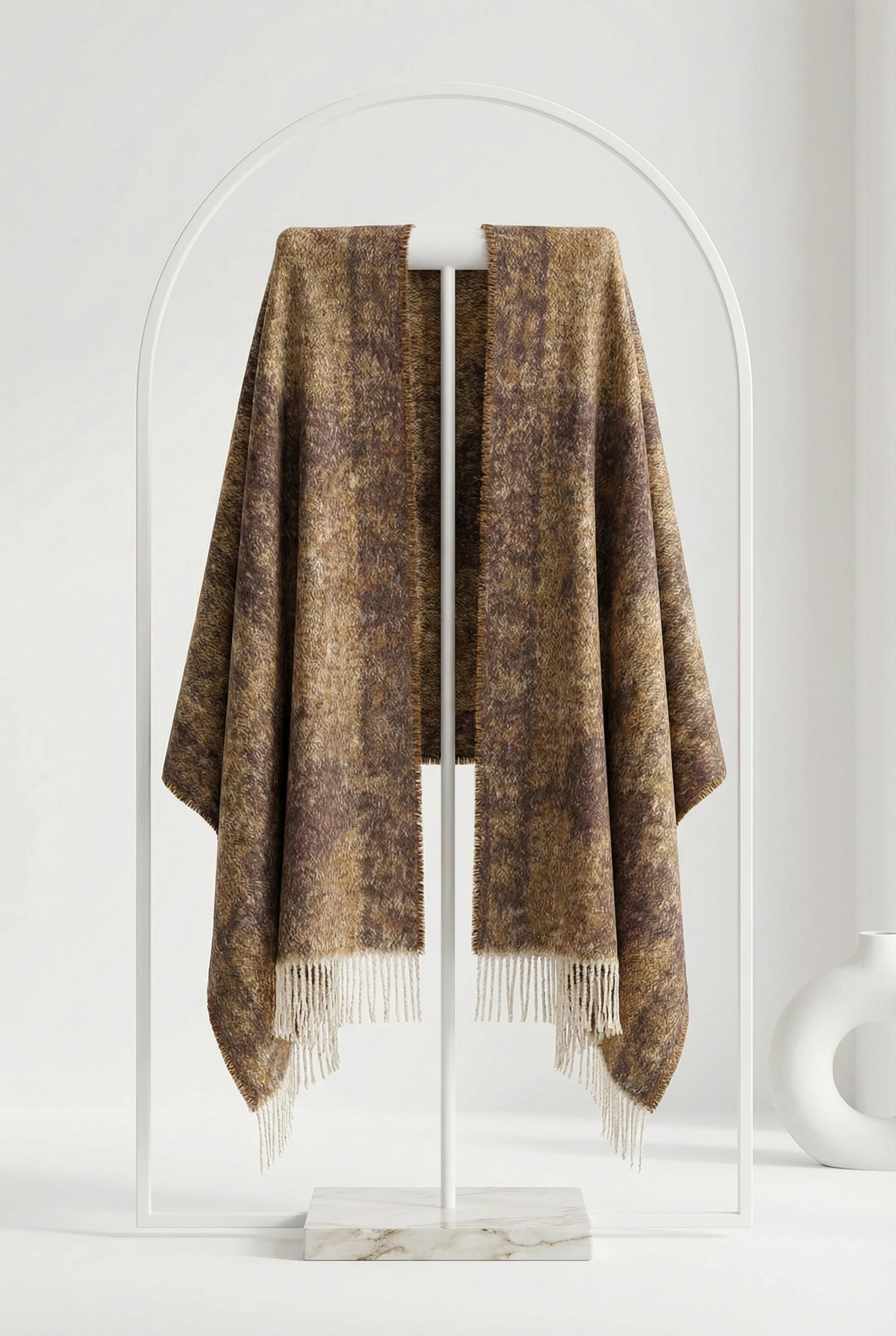 Brown plaid blanket draped over a white rack against a white background