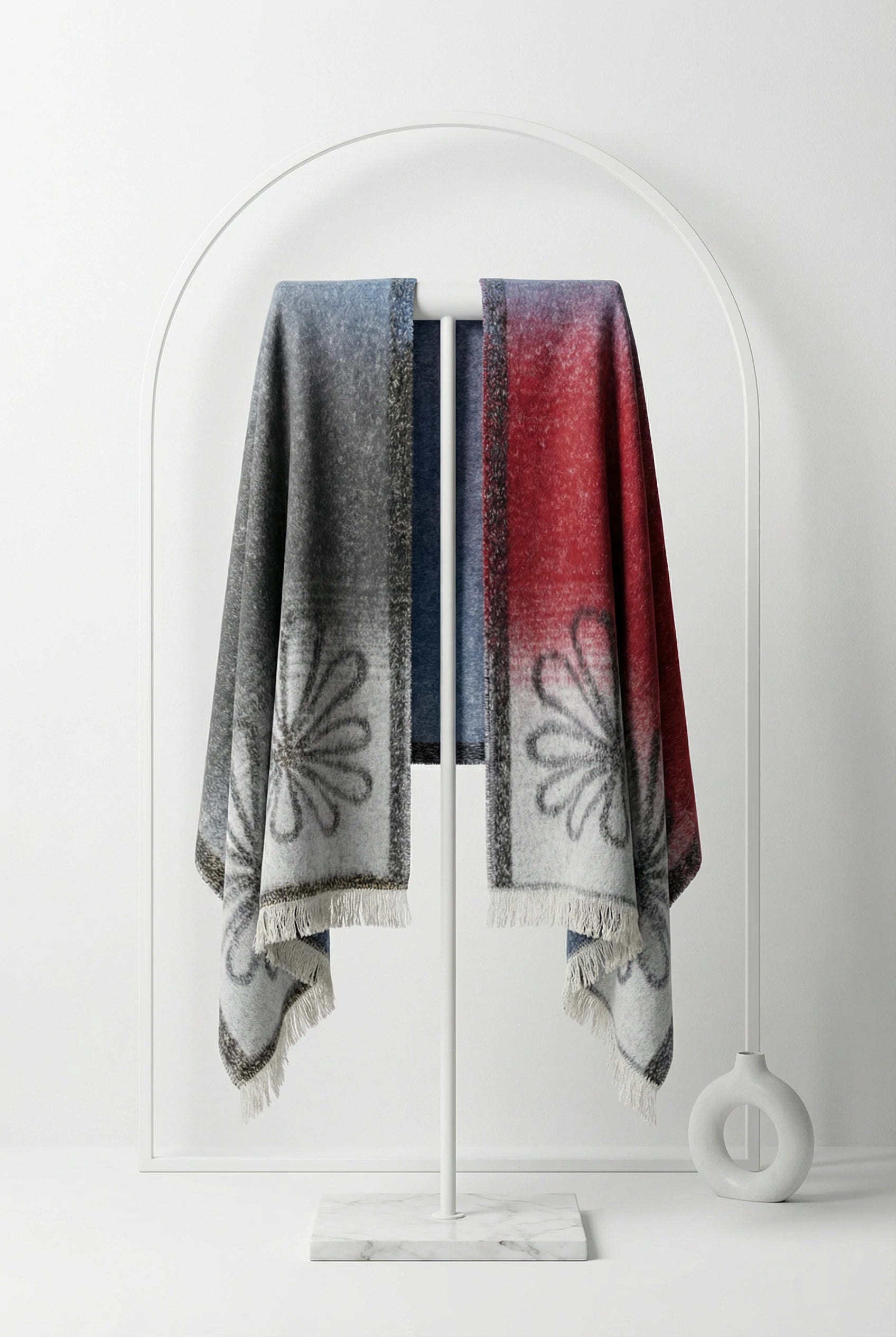 Two patterned scarves hanging on a white coat rack against a white background