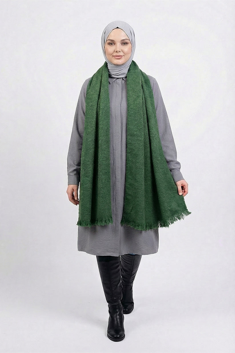 Woman wearing a green scarf and gray outfit on a white background