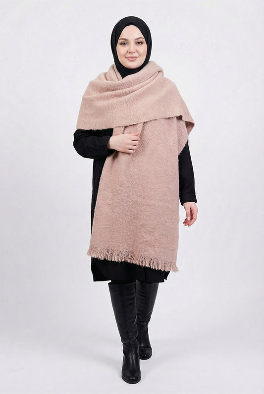 Woman wearing a large beige scarf on a white background