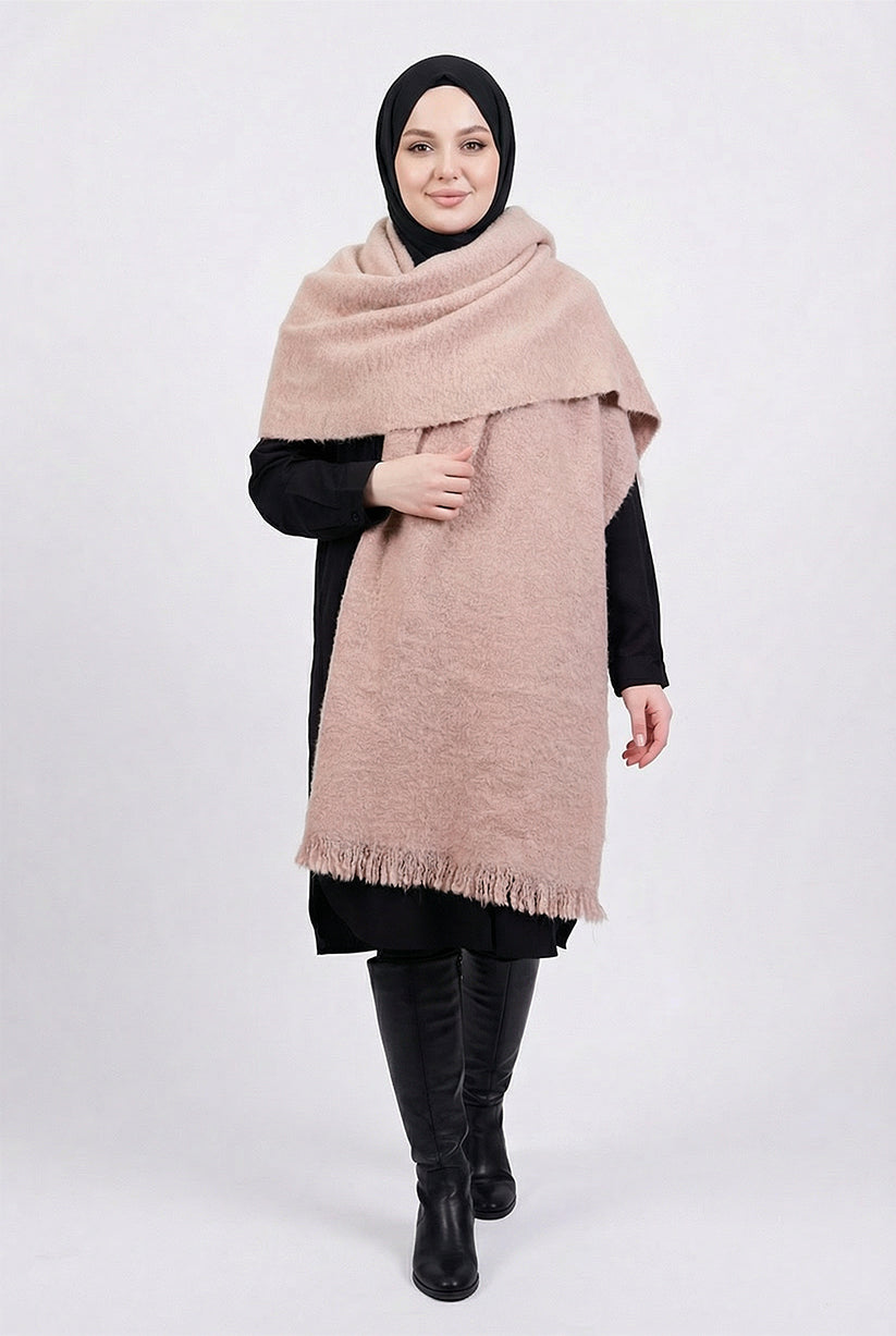 Woman wearing a large beige scarf on a white background