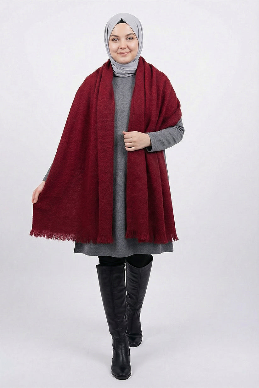 Woman wearing a red scarf, gray outfit, and black boots on a white background