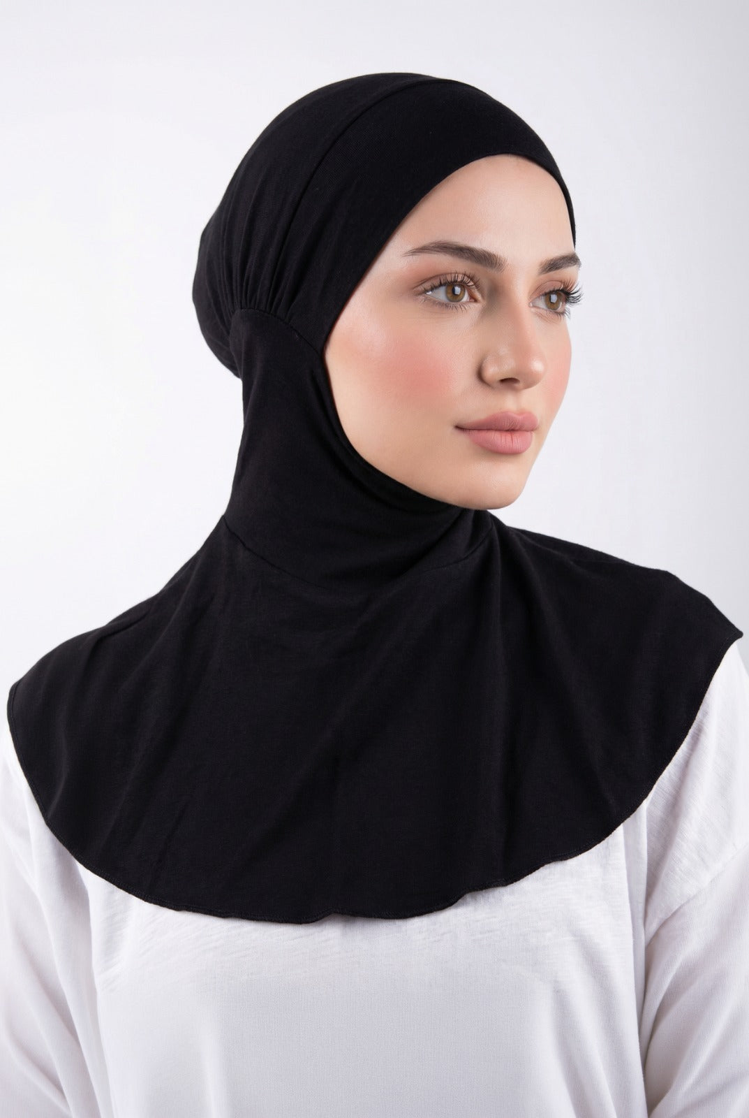 Woman wearing a black hijab against a white background