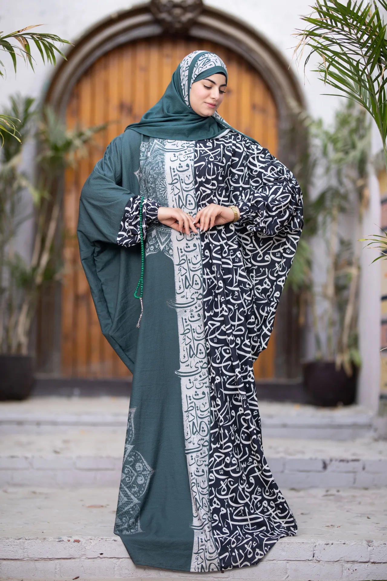 Model wearing Wajd isdal featuring artistic calligraphy patterns and calm tones
