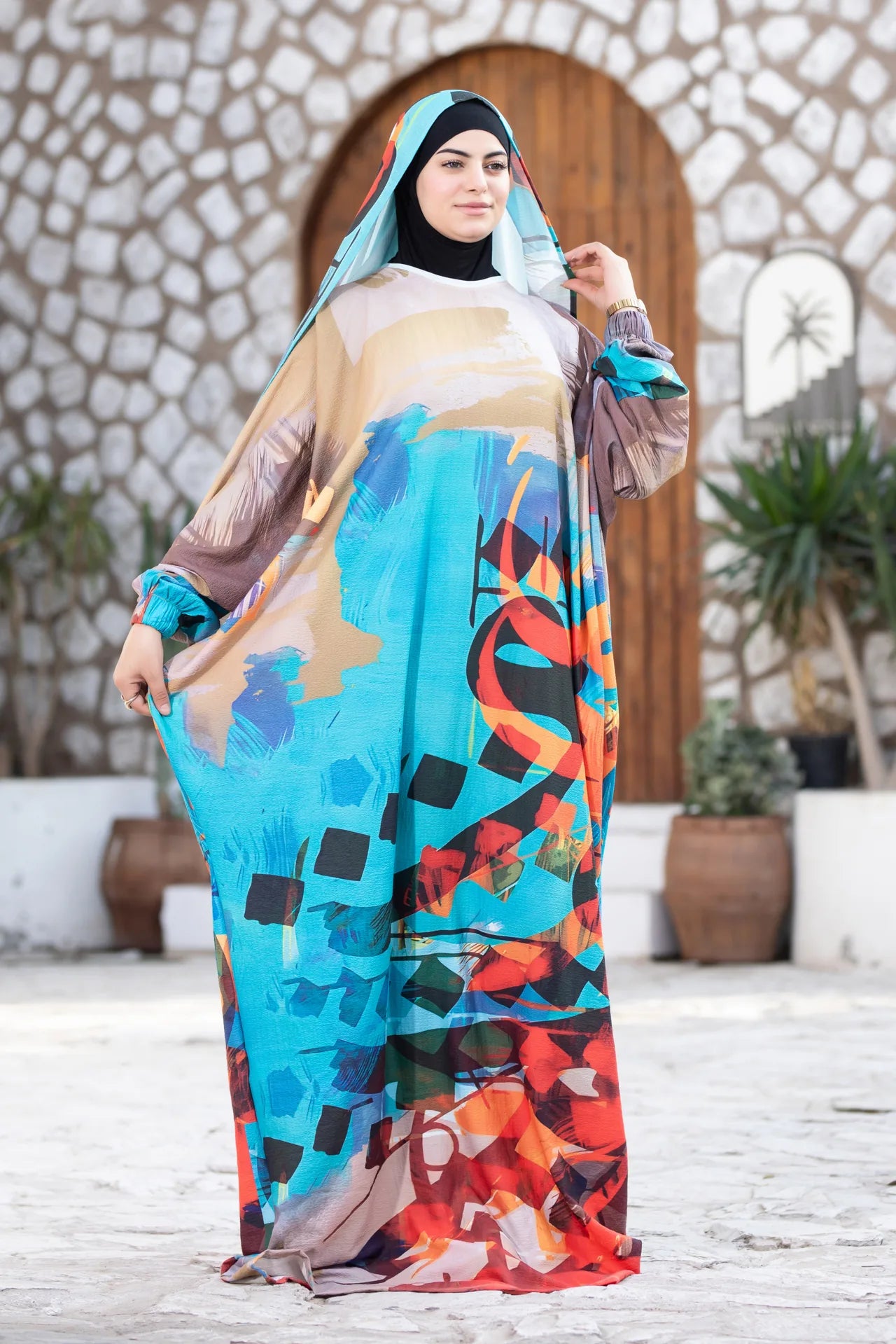 Model wearing Mawj garment with expressive colors and soft flowing design
