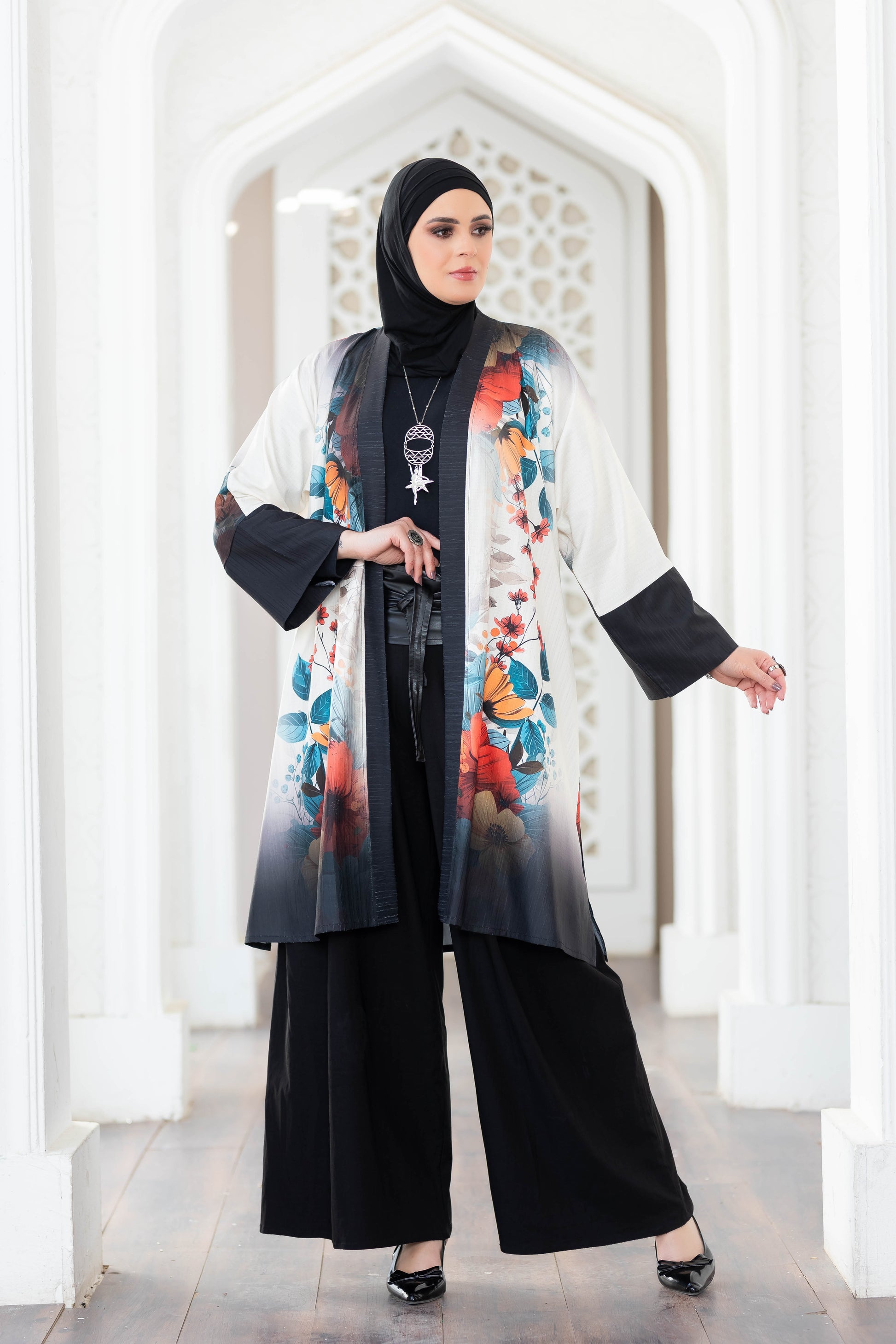 Colorful floral digital print kimono with flowing sleeves, showcased against a bright, ornate background in a fashion setting.