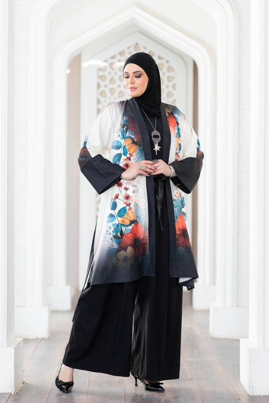 Vibrant floral-printed kimono with long bell sleeves, worn by a woman in traditional hijab, standing in an ornate architectural setting.