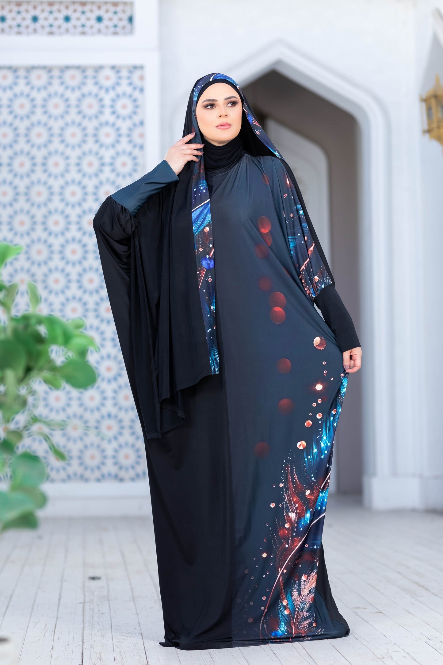 Modest Isdal 777175 abaya with floral pattern and vibrant colors, worn by a woman against tiled building background