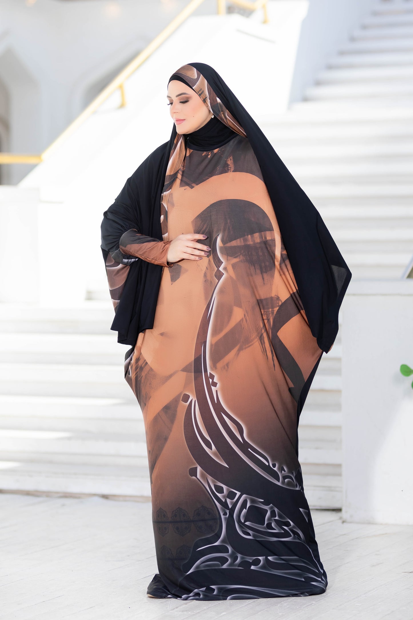 Modest Isdal 777181 - Elegant Arabic-inspired abaya with intricate floral patterns in earthy tones, complemented by a flowing silhouette.