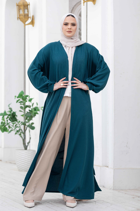 Elegant long teal kimono with wide cuffs displayed on female model in satr store