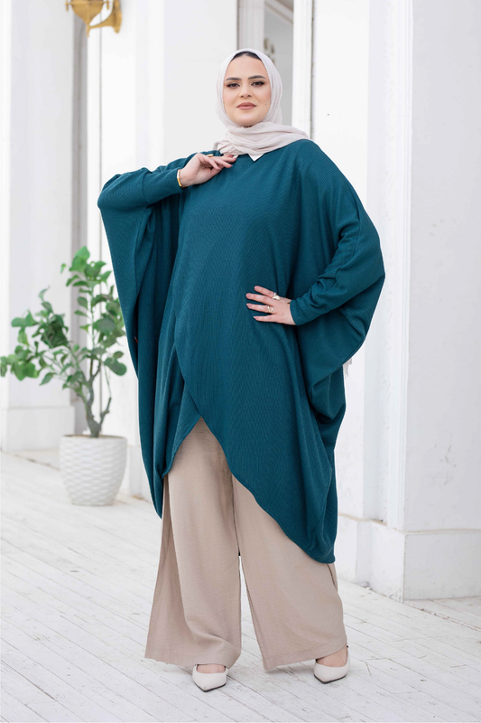 Elegant teal kimono with dramatic sleeves and a flowing silhouette, showcased by a confident woman wearing modest beige trousers and heels.