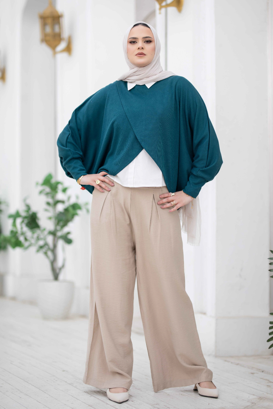 Elegant teal kimono with loose, flowing sleeves and a modest neckline, worn by a woman with a hijab in a stylish outfit.