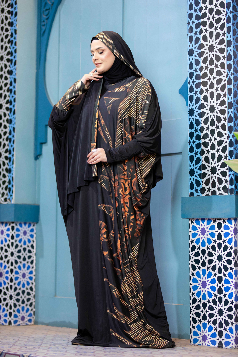 Stylish Islamic traditional clothing modeled against ornate blue and white tiled backdrop