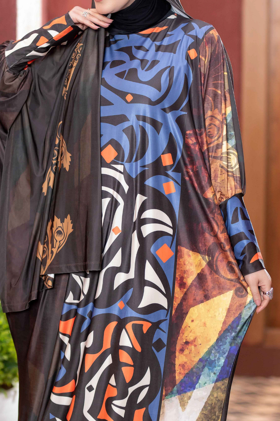 Vibrant patterned hijab with abstract shapes and bold colors, featured in a clothing store display.