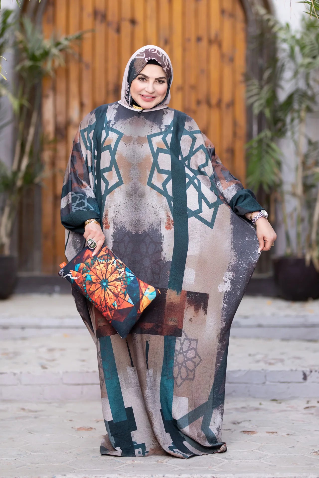 Woman wearing a patterned outfit with a headscarf, standing outdoors.